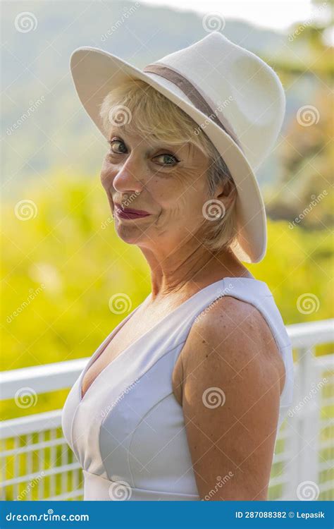 Street Portrait Of Stylish And Beautiful Blonde Woman 60 65 Years Old In A Fashionable Hat On