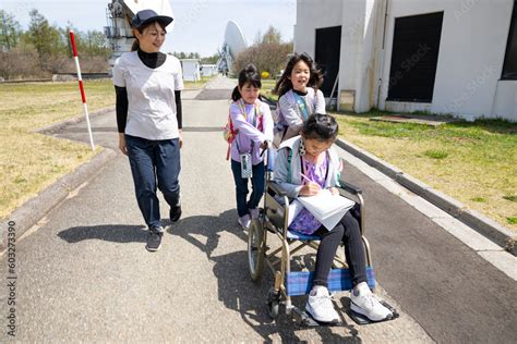 車いすに乗った女の子と学校の遠足に行く小学生の友達 Foto De Stock Adobe Stock