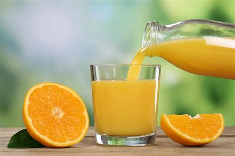 Premium Photo Orange Juice Pouring Into A Glass In Summer