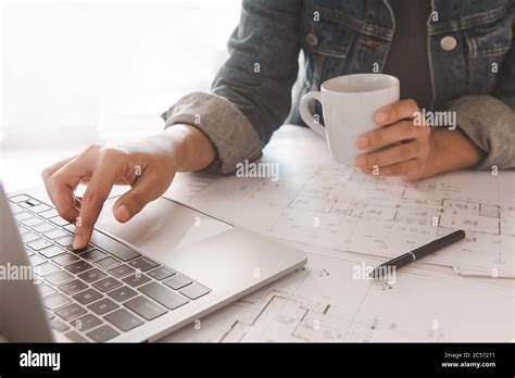 Engineer Holding Coffee Cup While Using A Computer Laptop To Planning