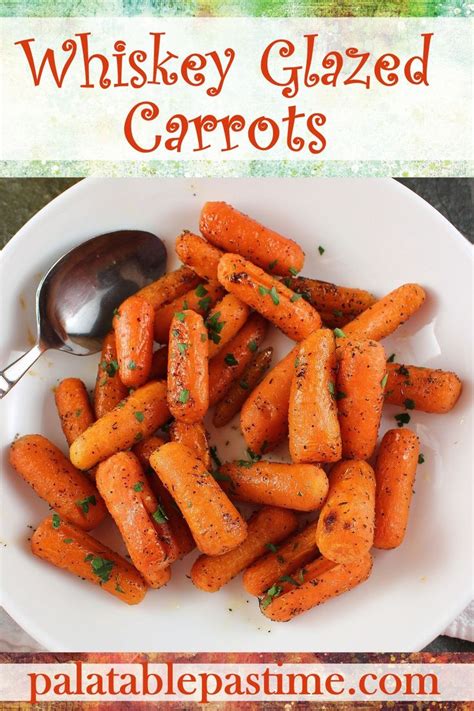 A White Plate Topped With Cooked Carrots Next To A Spoon