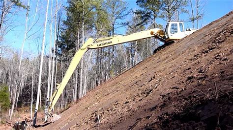 Long Reach Excavator Grading Steep Slope Youtube