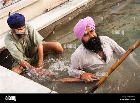 2 Sikh Men Cleaning The Pool At The Golden Temple Amritsar Punjab