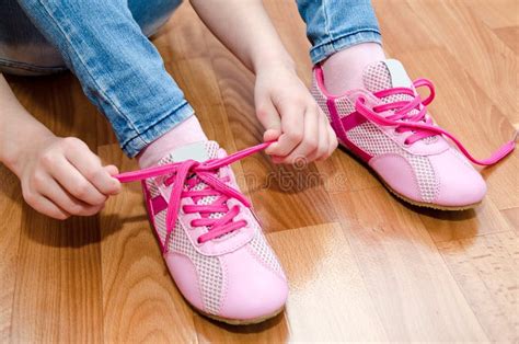 Petite Fille De Sourire Mignonne Attachant Ses Chaussures Photo Stock