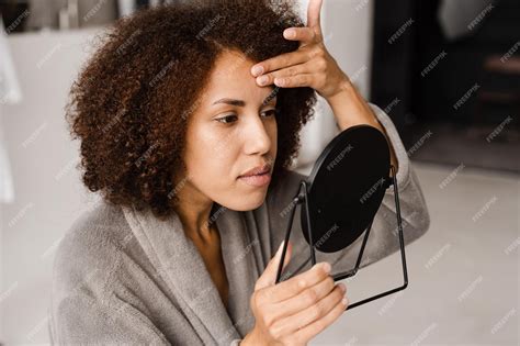 Une Fille Africaine Regarde Des Boutons Dacné Sur Son Visage Dans Le