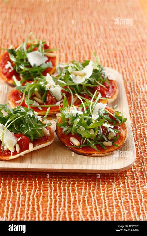 Rocket Lettuce And Confit Tomato Mini Pizzas Stock Photo Alamy