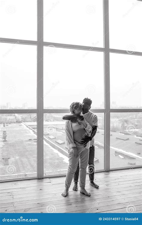 Young African Man Stands Embraces His Caucasian Pregnant Woman And