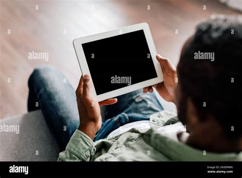 Mature African American Male Watching Video On Tablet With Empty Screen