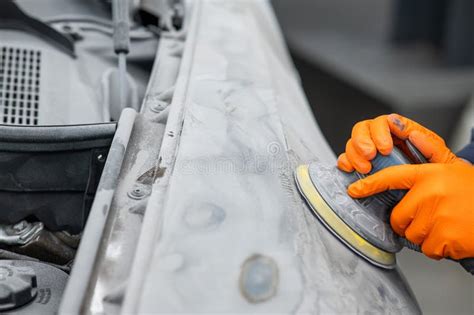 A Mechanic Sands The Putty On A Car Body With A Machine Repair After