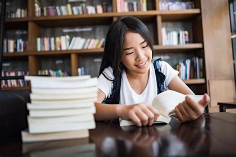 Premium Photo Smiling Woman Reading Book While Sitting At Cafe