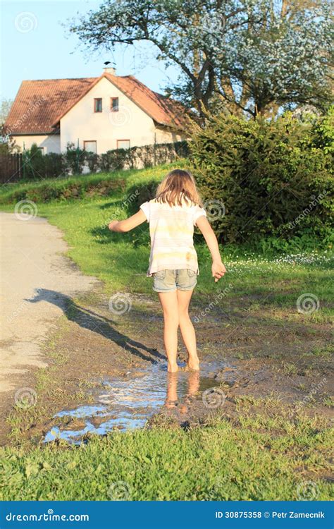 Little Girl In Muddy Puddle Stock Photo - Image: 30875358