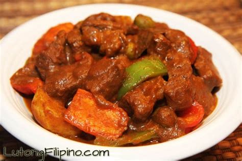 A Close Up Of A Plate Of Food With Meat And Vegetables In It On A Table