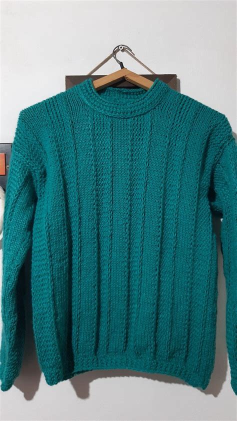 A Green Sweater Hanging On A Wooden Hanger