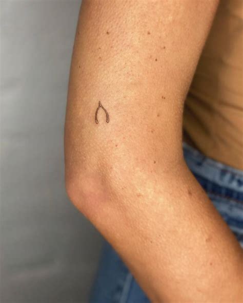 Tiny Minimalistic Wishbone Tattoo Located On The Upper