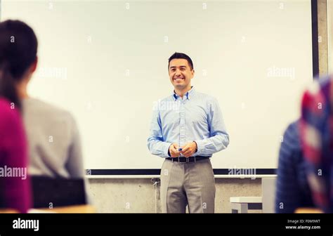 group of students and smiling teacher in classroom Stock Photo - Alamy