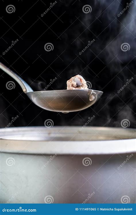 Pork Rip In Soup Scoop With Stainless Hot Pot Water Drop Onion And Vapour On Black Background