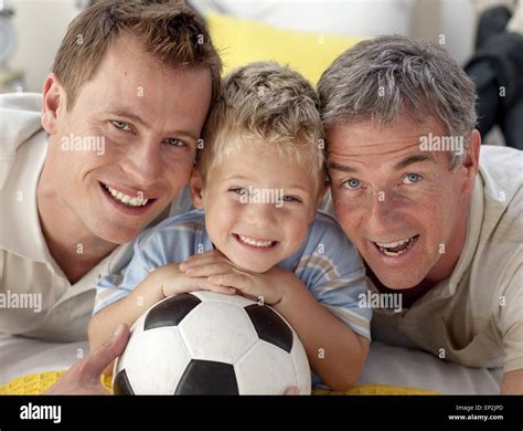 Portrait Of Smiling Son Father And Grandfather On Floor Stock Photo