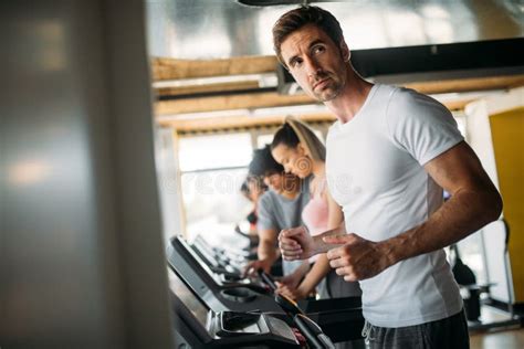 Grupo De Jovens Que Correm Na Escada Rolante No Gym Imagem De Stock