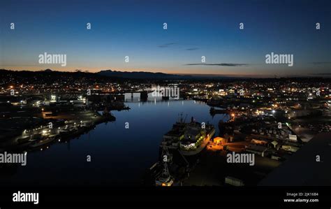 An Aerial View Of A City With Buildings And A Port Illuminated At Night