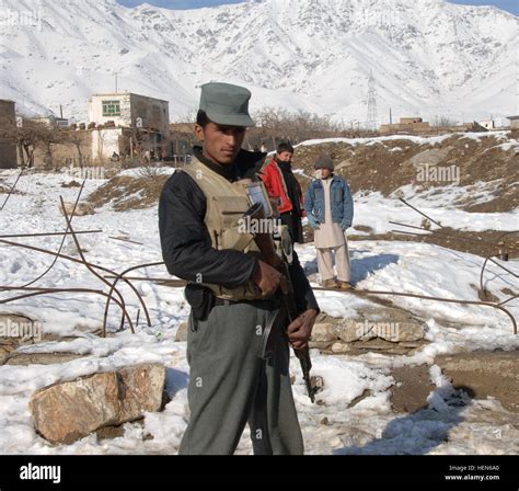 An Afghanistan National Policeman Patrols The Village Of Charikar