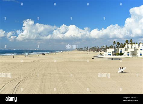 HUNTINGTON BEACH CALIFORNIA 7 DEC 2022 Two Surfers Draging Their