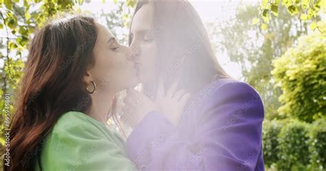 Two Pretty Lesbian Woman Embracing And Kissing At Sunny Summer Park Female Couple In Love Have