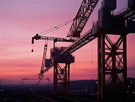 Some Construction Cranes On A Bridge At Sunset Background Crane