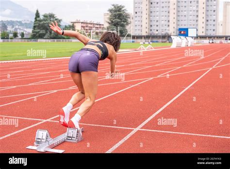 Full Body Back View Of Determined Young Female Sprinter Starting To Run