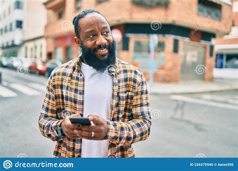 African American Man With Beard Using Smartphone Typing And Texting At