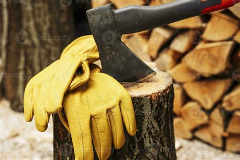 axe stuck in a wooden deck and protective yellow leather gloves 25061253 Stock Photo at Vecteezy