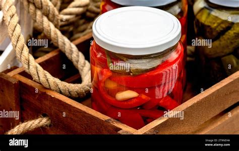 Wooden Crate With Glass Jars With Pickled Red Bell Peppers And Pickled