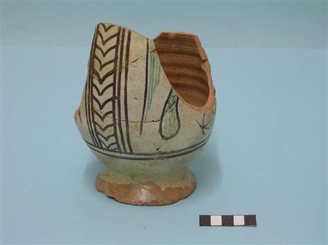 An Old Ceramic Vase Sitting On A Blue Surface With A Stripe In The