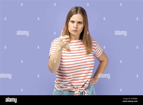 Portrait Of Blond Woman Wearing Striped T Shirt Pointing Finger At