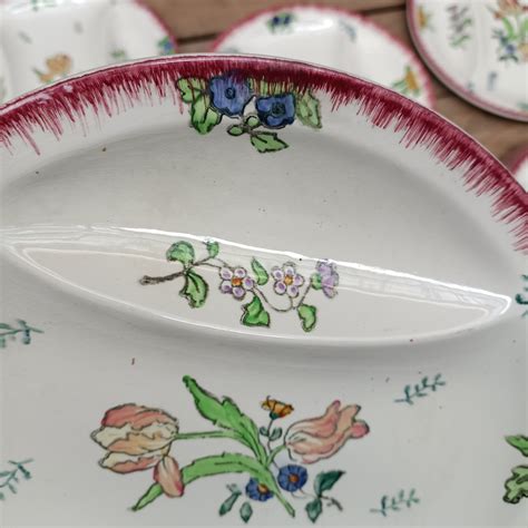 12 assiettes à compartiments en faïence ancienne à décor floral modèle