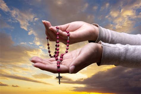 Praying Hands With Rosary Beads And Clouds