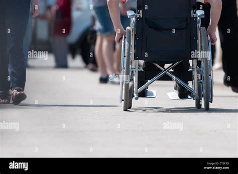 Disabled Handicapped Person On Wheeled Chair Among People Without