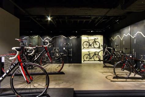 There Are Many Bikes On Display In The Room With Black Walls And