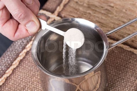 Adding powdered gelatin to water. | Stock image | Colourbox