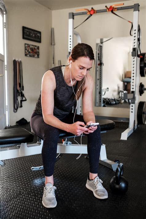 Woman Listening To Music While Working Out In The Home Gym By Stocksy