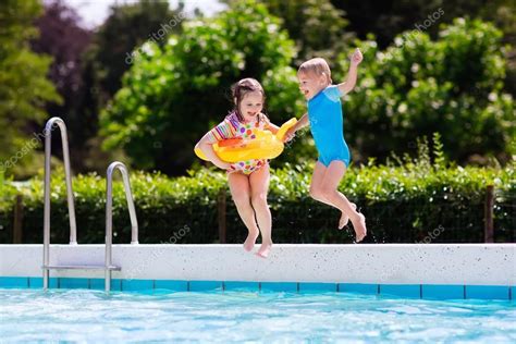 Crianças pulando na piscina fotos, imagens de © FamVeldman #118020732