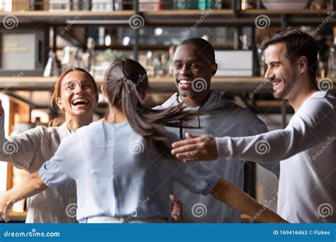 Happy Diverse Friends Giving Hug Meeting Girlfriend In Cafe Stock Image