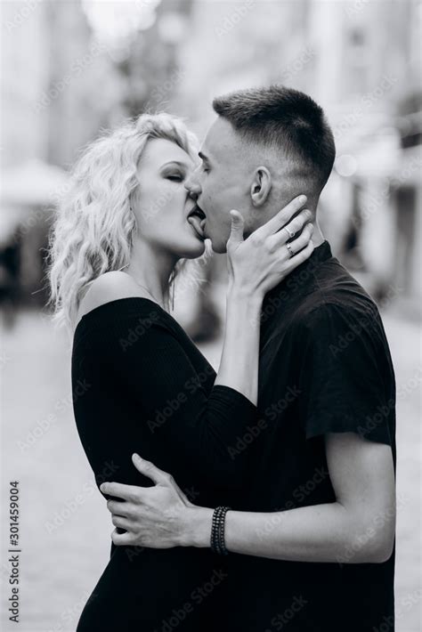 Black and white portrait of loving couple kissing on the street. Hot french kiss Stock Photo ...