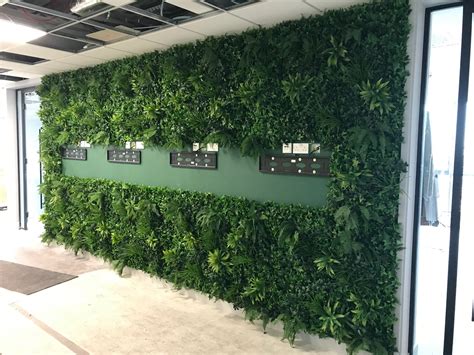 Artificial green wall panel with variegated foliage ivy palms grasses - greenplantwalls.co.uk