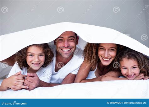 Retrato De La Familia Feliz Que Miente Debajo De Un Bedsheet Imagen De