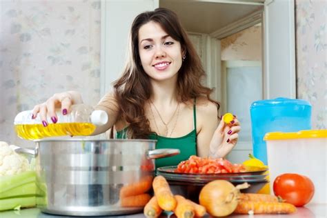 Jeune Femme Au Foyer Cuisiner Avec De L Huile Photo Gratuite