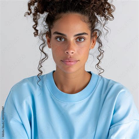 4 Relaxed American Latina Woman With Curly Hair Pulled Back In A Bun Wearing A Plain Light