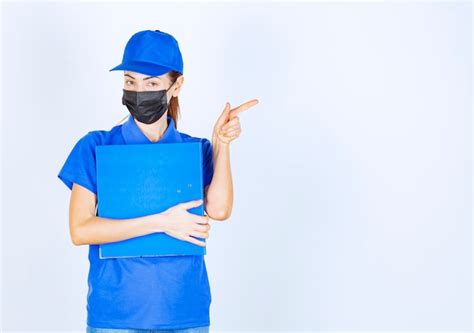 Premium Photo Woman In Blue Uniform And Black Face Mask Holding A