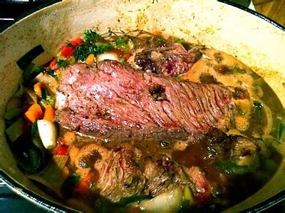 A Pot Filled With Meat And Vegetables On Top Of A Stove