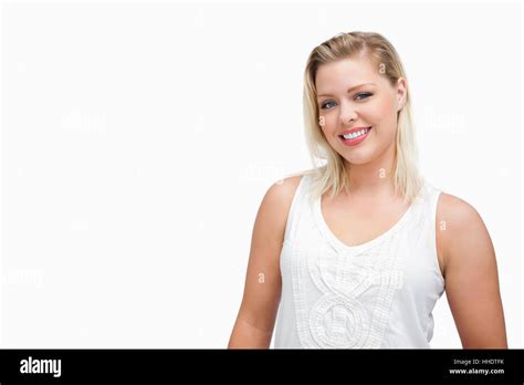 Smiling Blonde Woman Standing Upright Against A White Background Stock Photo Alamy
