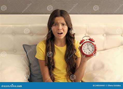 Worried Girl Child Hold Alarm Clock Being Upset With Oversleeping